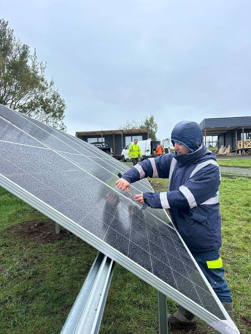 Técnico instalando paneles solares en la Región de Los Lagos